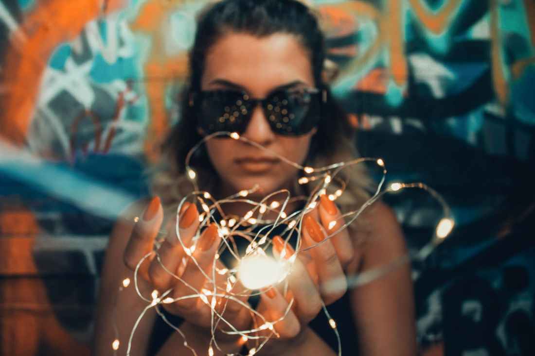 woman holding white string lights